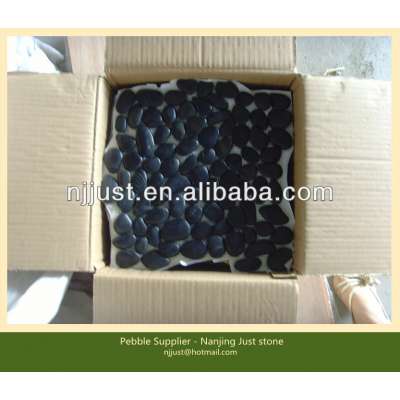 Interlocking polished black pebble tile packed in cartons